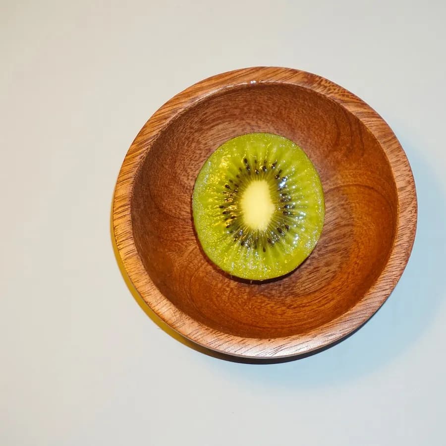 A kiwi halved and set in a wooden bowl