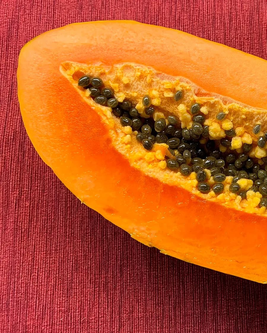 A papaya split lengthwise, its flesh deep orange